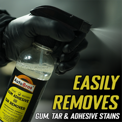 Hand holding a bottle of AutoBros gum, tar, and adhesive remover with text on a dark background