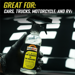Bottle of AutoBros gum adhesive and tar remover held by a gloved hand with text indicating its use on cars, trucks, motorcycles, and RVs.